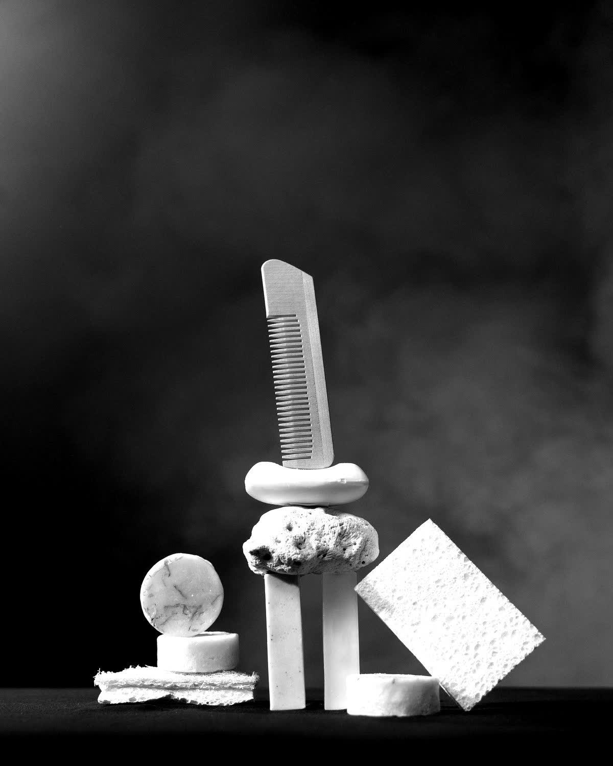 Minimal black and white still life of skincare tools and natural stone