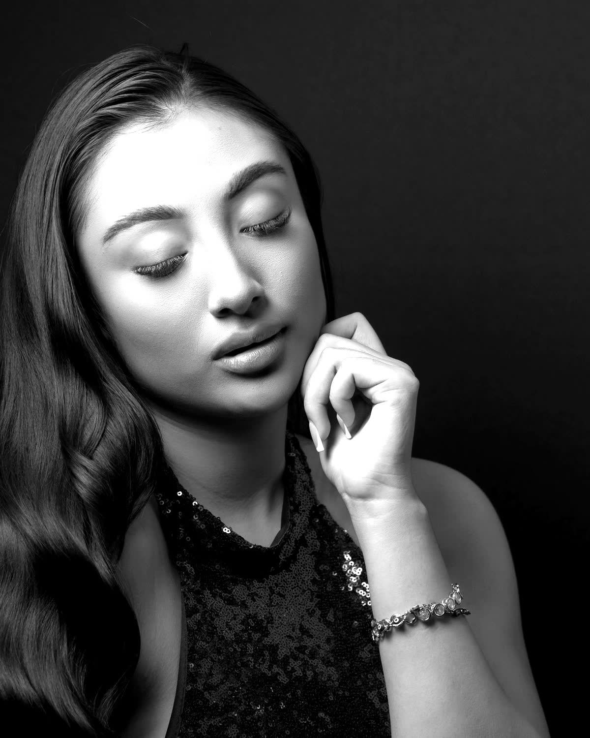 Black and white editorial portrait of a woman with clear, radiant skin